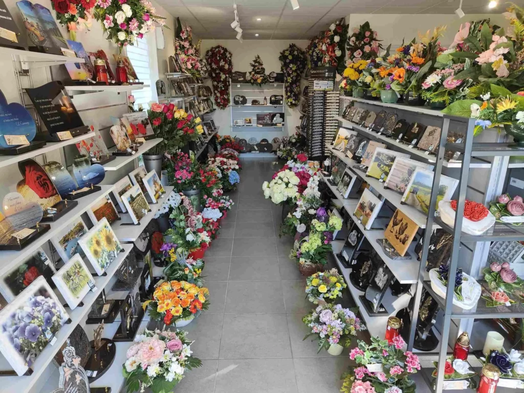 Boutique funéraire exposant de nombreuses plaques commémoratives et fleurs